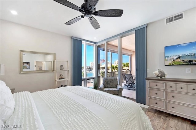 bedroom featuring ceiling fan, access to exterior, light wood-type flooring, and floor to ceiling windows