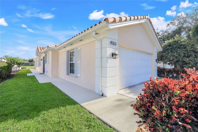 view of home's exterior featuring a garage and a yard