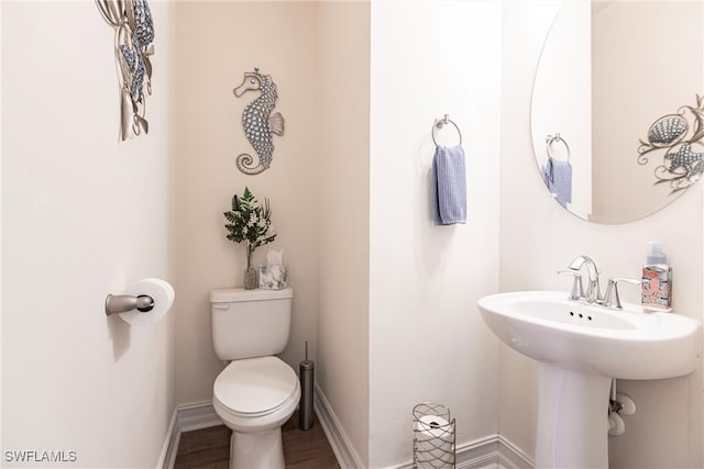 bathroom featuring wood-type flooring, sink, and toilet