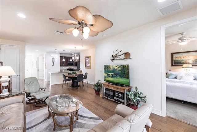 living room with hardwood / wood-style floors and ceiling fan