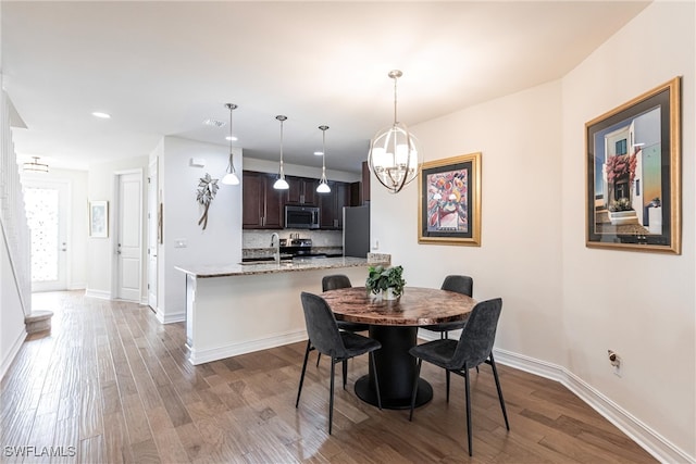 dining space featuring sink, a chandelier, and hardwood / wood-style floors