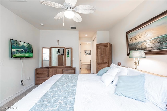 carpeted bedroom with ceiling fan and ensuite bath