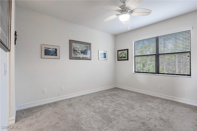 spare room with ceiling fan and light carpet