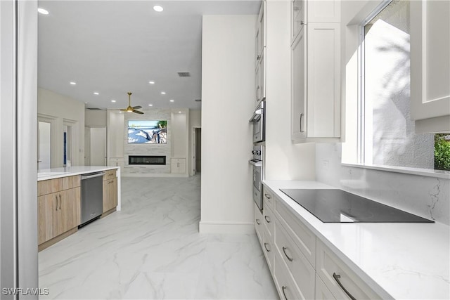 kitchen featuring a wealth of natural light, white cabinetry, ceiling fan, and appliances with stainless steel finishes