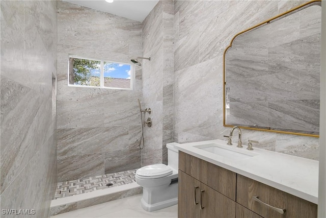 bathroom featuring tiled shower, vanity, tile walls, and toilet