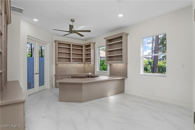 unfurnished office featuring french doors, plenty of natural light, and ceiling fan