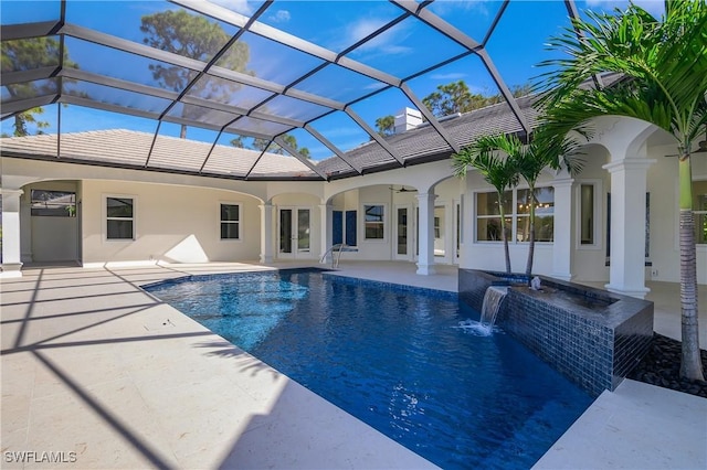 view of swimming pool featuring pool water feature, a patio area, a lanai, and a hot tub