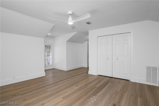 additional living space with ceiling fan, vaulted ceiling, and light wood-type flooring