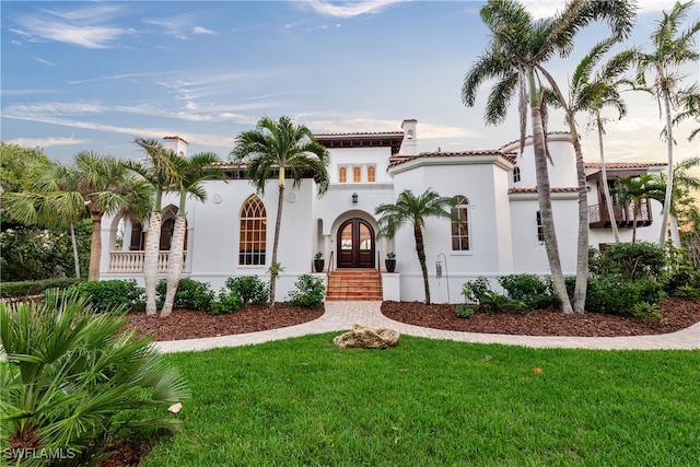 mediterranean / spanish-style house featuring a front lawn