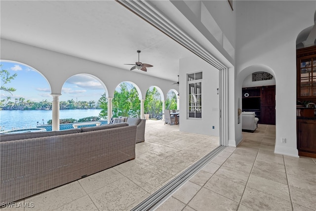 view of patio / terrace with an outdoor living space, a water view, and ceiling fan