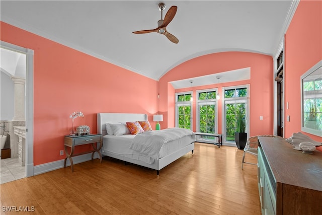 bedroom featuring light wood-type flooring, ceiling fan, vaulted ceiling, connected bathroom, and crown molding