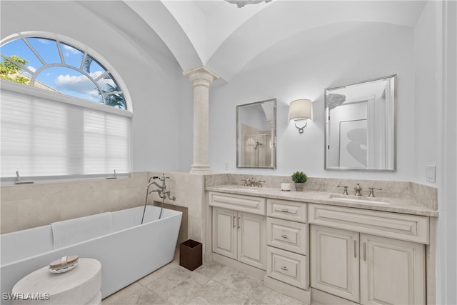 bathroom with lofted ceiling, a tub, ornate columns, vanity, and tile patterned flooring