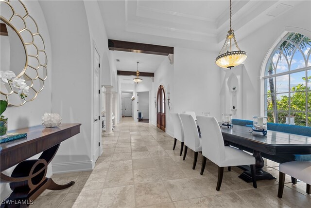 dining room with a raised ceiling and decorative columns