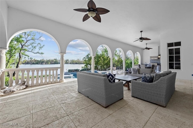 view of patio / terrace with outdoor lounge area, a water view, and ceiling fan