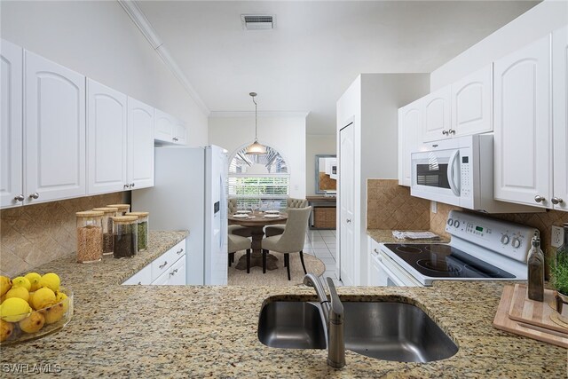 kitchen with decorative backsplash, white appliances, decorative light fixtures, and white cabinets