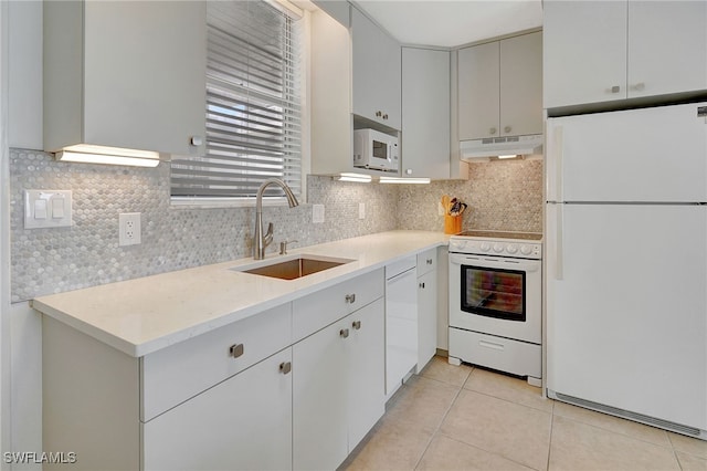 kitchen with white appliances, light tile patterned floors, tasteful backsplash, and sink