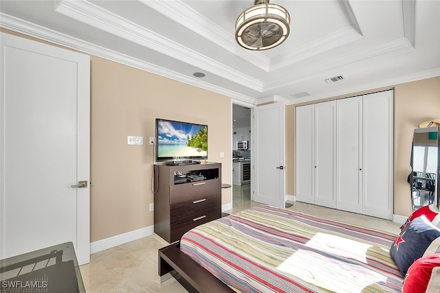 bedroom with a closet, crown molding, and a tray ceiling