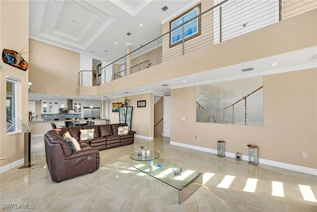 living room with a towering ceiling and crown molding