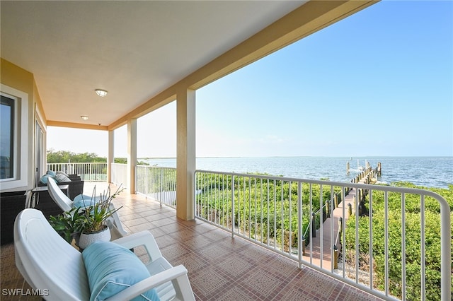 balcony with a water view and a dock