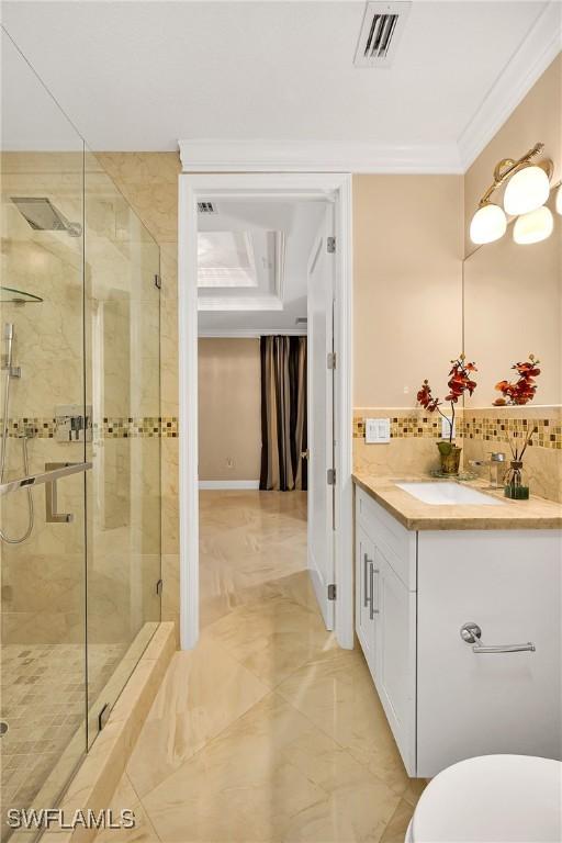 bathroom featuring vanity, crown molding, walk in shower, and tasteful backsplash