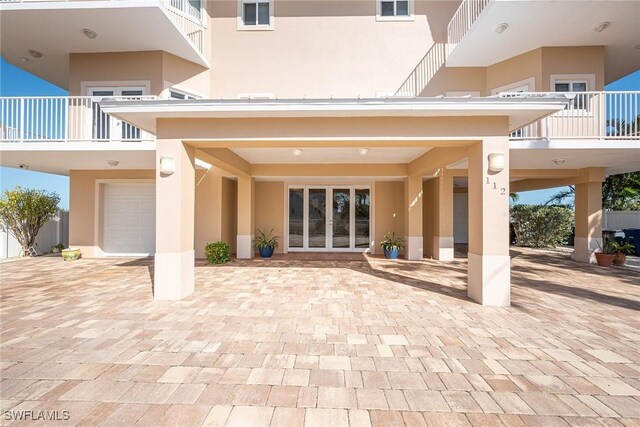 rear view of property featuring french doors and a garage