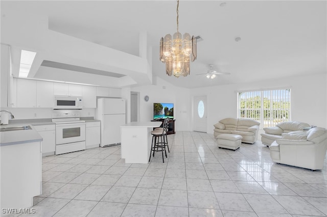 kitchen with ceiling fan with notable chandelier, a kitchen bar, pendant lighting, white cabinets, and white appliances