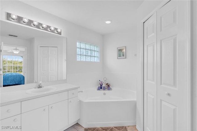 bathroom featuring vanity, a tub, tile patterned flooring, and ceiling fan