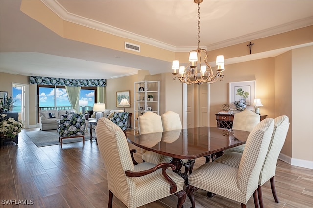 dining room featuring crown molding, a notable chandelier, and wood-type flooring