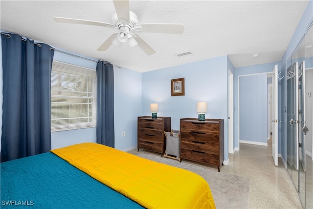 bedroom with a textured ceiling and ceiling fan