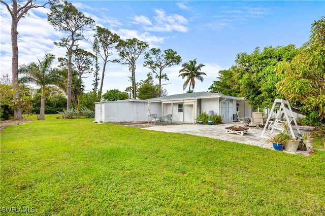 rear view of house featuring an outdoor fire pit, a patio, and a yard