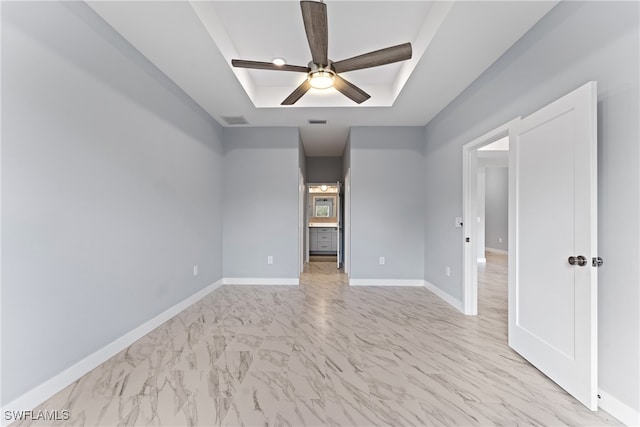 spare room with a raised ceiling and ceiling fan