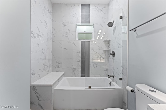 bathroom featuring toilet and tiled shower / bath