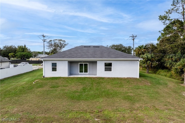 rear view of house featuring a lawn