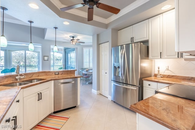 kitchen featuring white cabinets, stainless steel appliances, sink, and decorative light fixtures