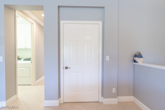 corridor featuring light tile patterned flooring and independent washer and dryer