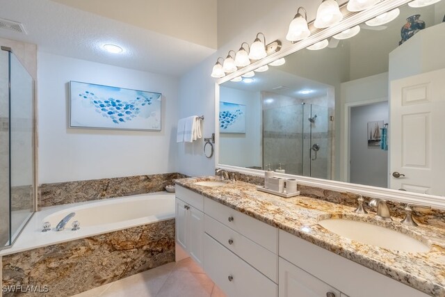 bathroom with tile patterned flooring, shower with separate bathtub, a textured ceiling, and vanity