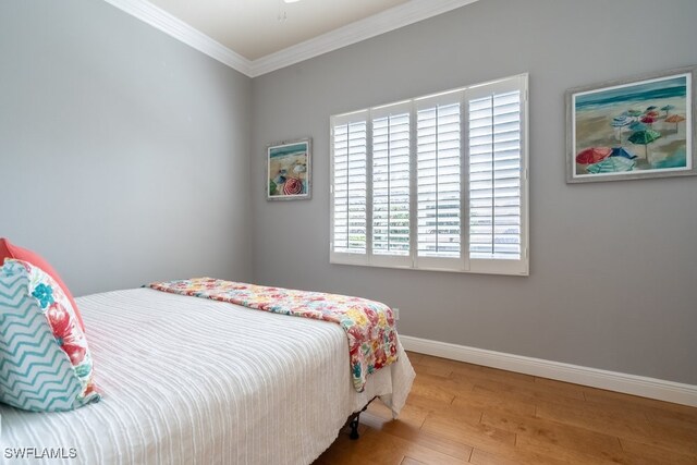 bedroom with light wood-type flooring and ornamental molding