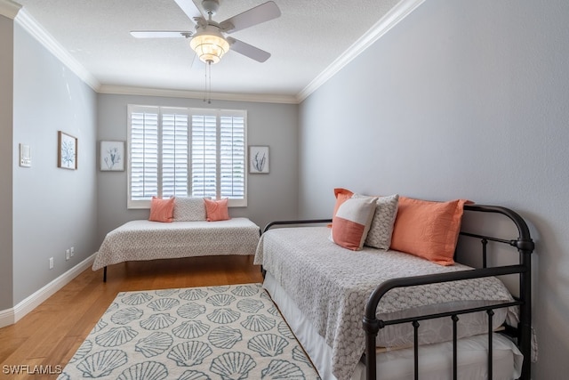 bedroom with ceiling fan, light hardwood / wood-style floors, and crown molding