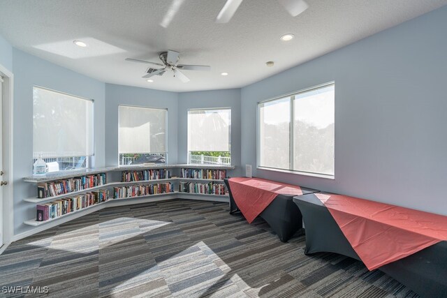 recreation room featuring ceiling fan and a textured ceiling