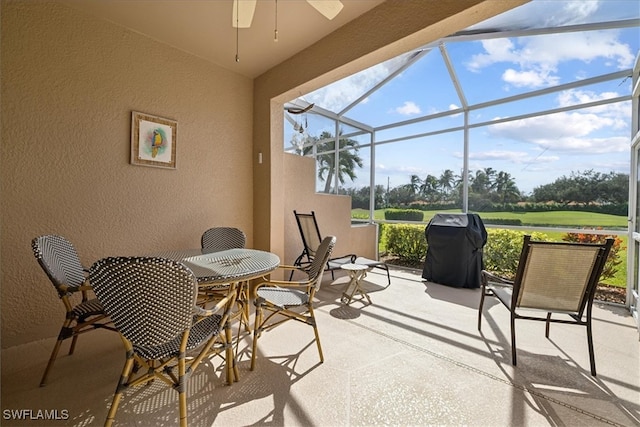 view of patio / terrace with grilling area, glass enclosure, and ceiling fan