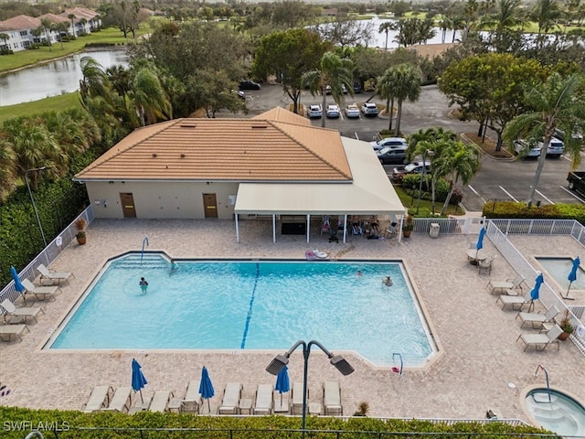 view of pool with a patio area and a water view