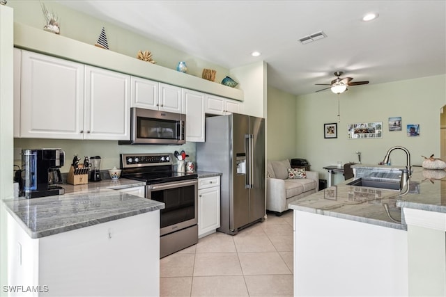 kitchen with sink, light tile patterned flooring, ceiling fan, stainless steel appliances, and white cabinets