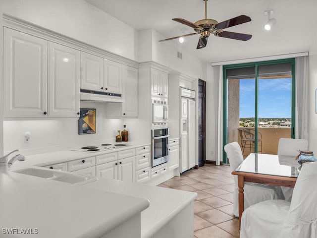 kitchen featuring sink, light tile patterned flooring, white cabinets, white appliances, and ceiling fan