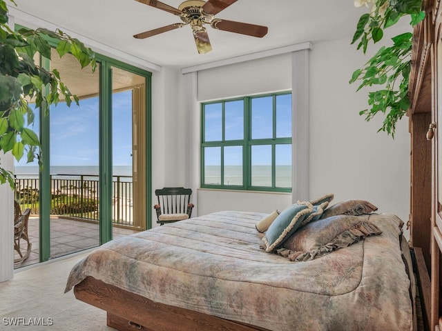 carpeted bedroom featuring a water view, access to outside, and ceiling fan