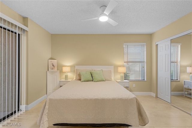 tiled bedroom featuring a textured ceiling, a closet, and ceiling fan