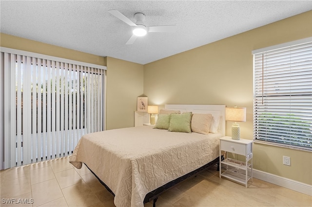 tiled bedroom featuring a textured ceiling and ceiling fan