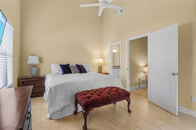 bedroom featuring connected bathroom, a high ceiling, and ceiling fan