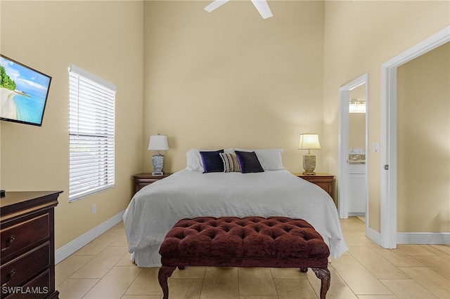 bedroom featuring a towering ceiling, light tile patterned floors, and ceiling fan