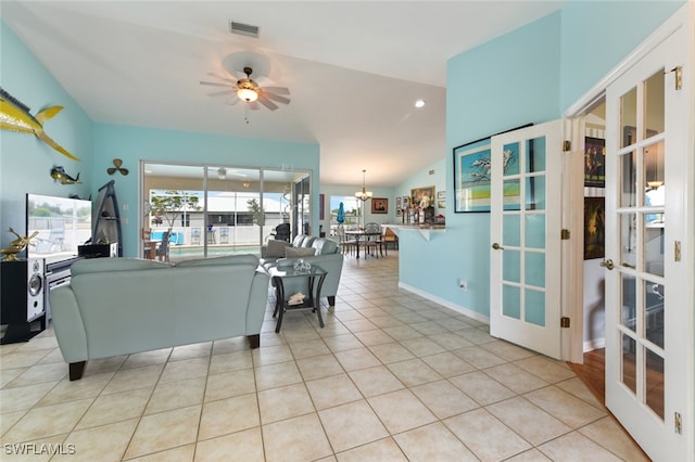 tiled living room featuring french doors, vaulted ceiling, and ceiling fan with notable chandelier