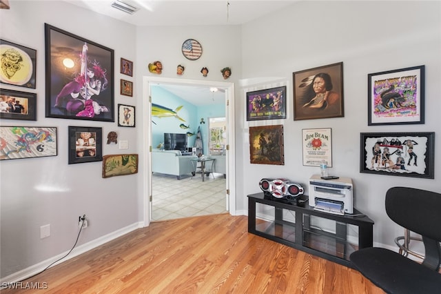 hallway featuring lofted ceiling and light hardwood / wood-style floors